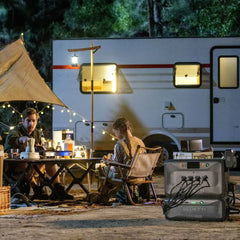 BLUETTI portable power station setup at campsite with family and RV at night