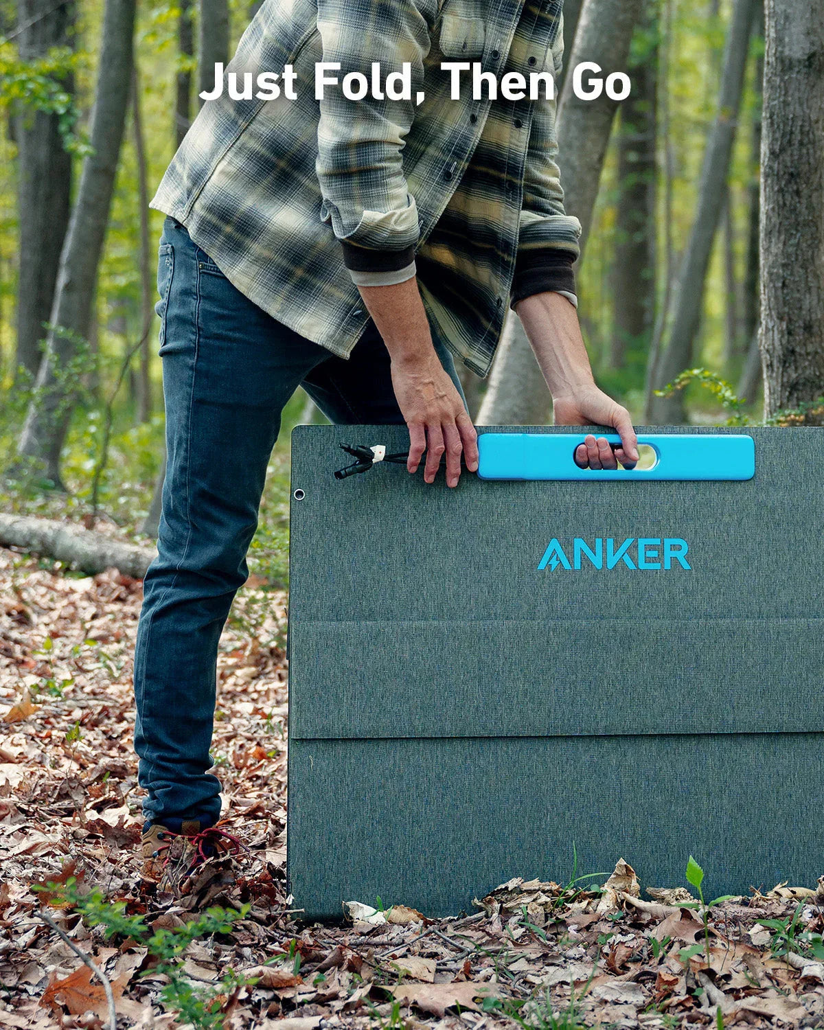 Anker portable solar panel being carried outdoors in a forest by a person in casual attire