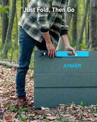 Anker portable solar panel being carried outdoors in a forest by a person in casual attire