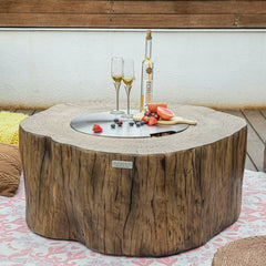 Elementi Manchester fire pit table with red wood finish, steel lid, and outdoor drinks setup