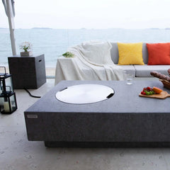 Elementi Metropolis light gray fire pit table on patio with sofa and ocean view