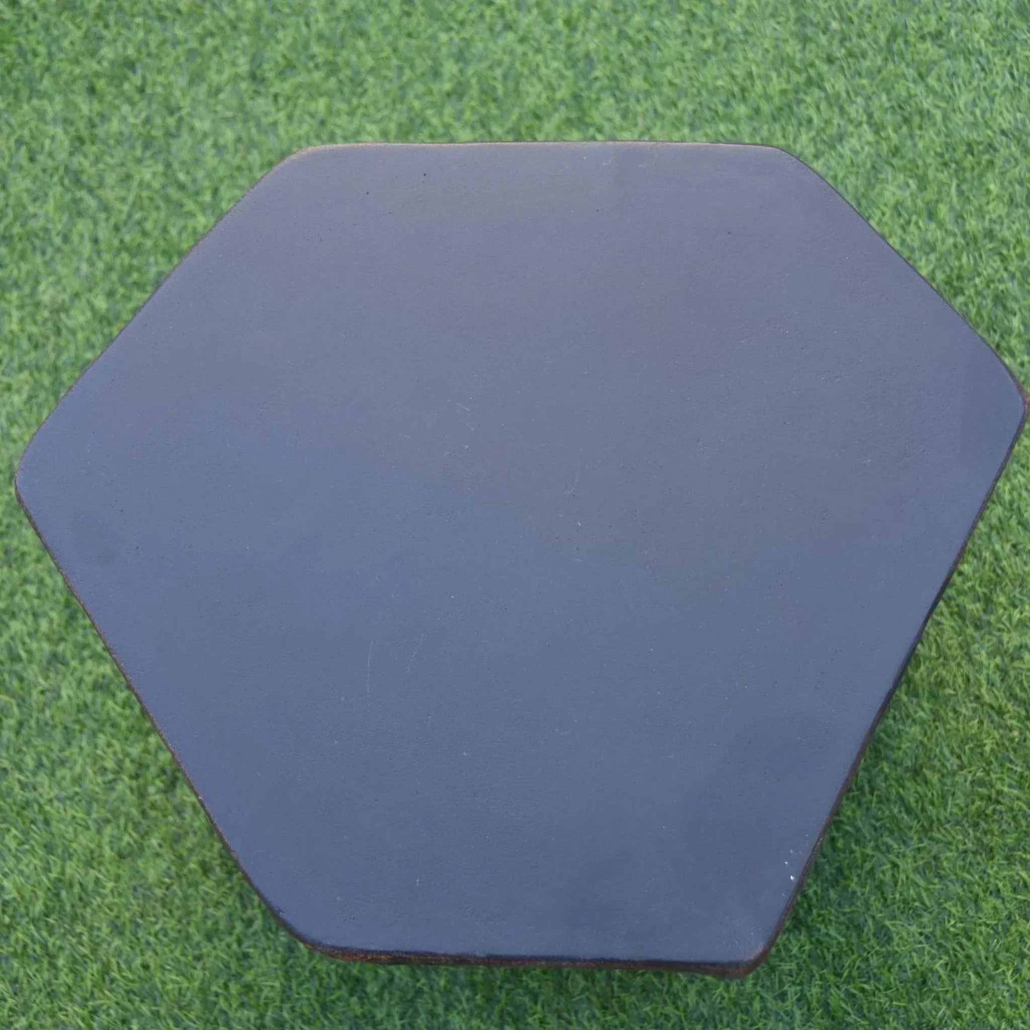 Elementi black hexagonal seat accessory on green artificial grass