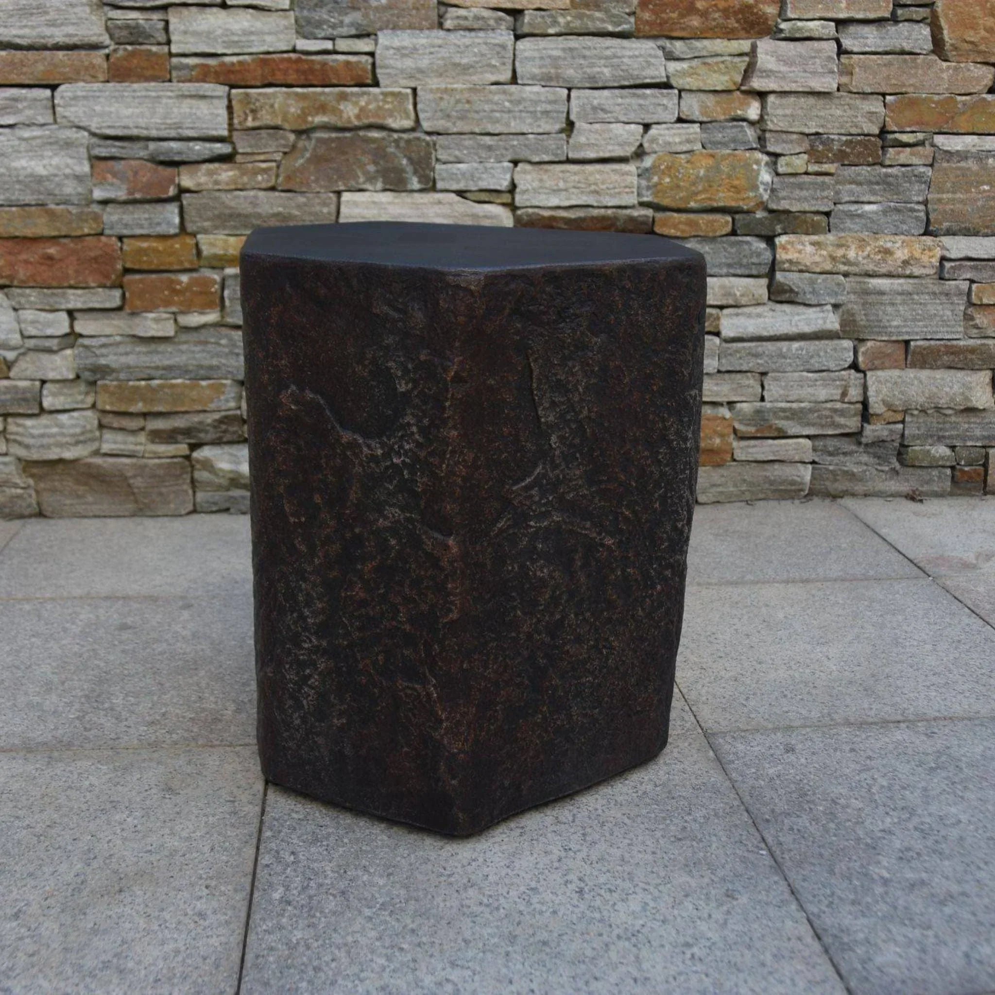 Elementi Columbia outdoor rustic stone-look seat against a stone wall