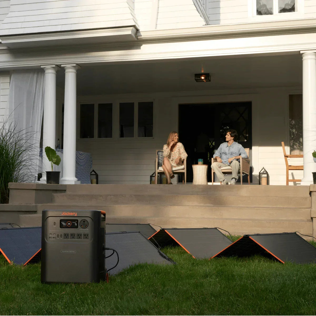 Jackery portable power station with solar panels set up outdoors in front of a house