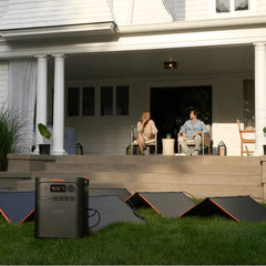 Jackery portable power station with solar panels set up outdoors in front of a house