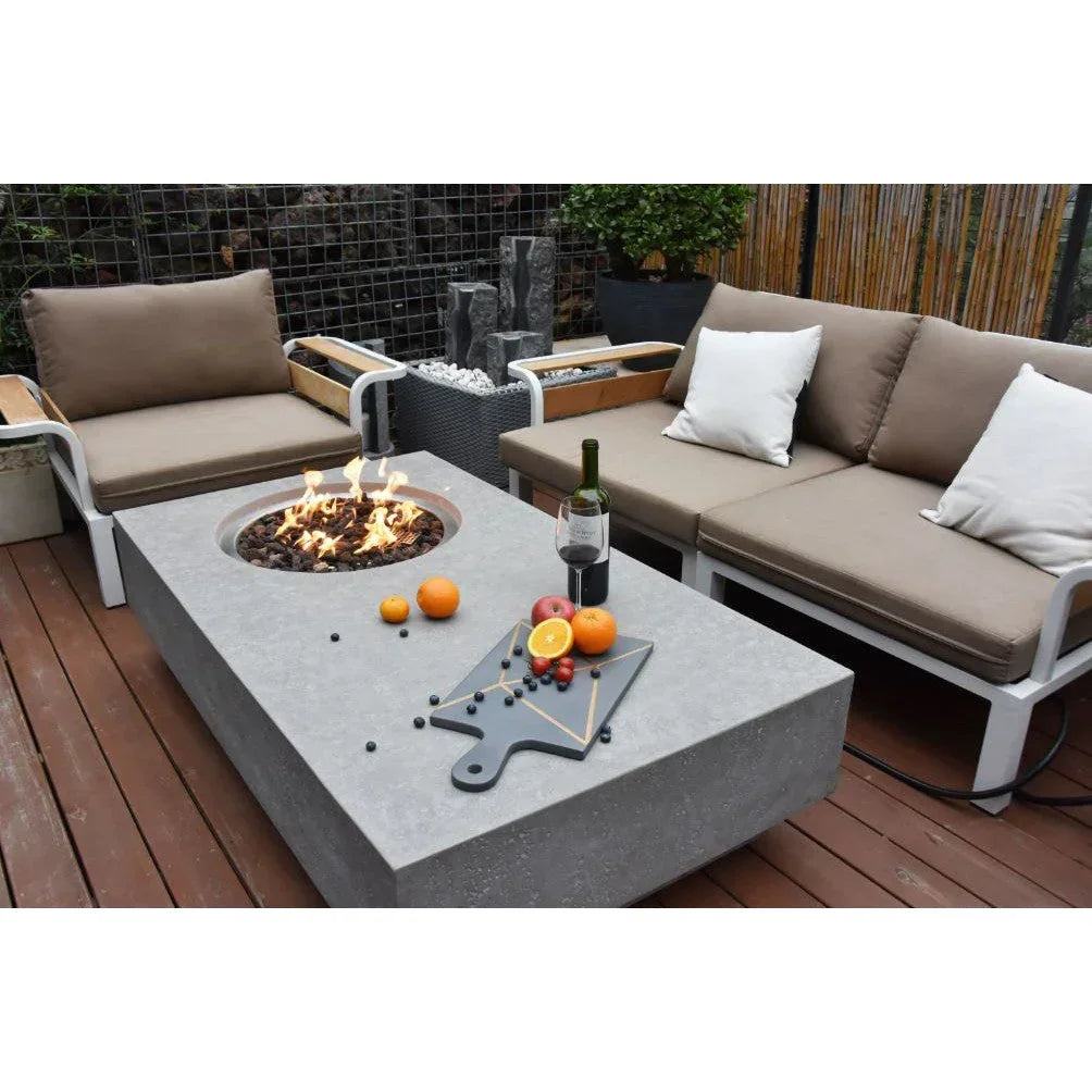 Metropolis modern outdoor fire pit table set with beige cushioned sofas, wine, and fruit