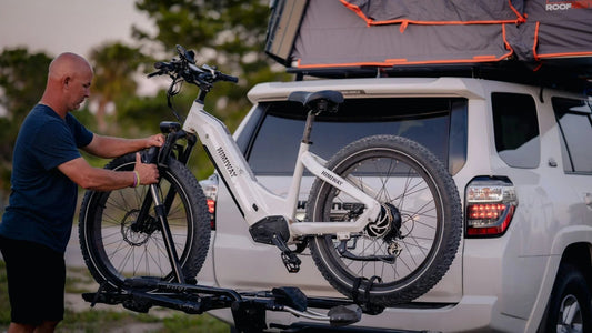 Himiway electric bike being mounted on SUV bike rack outdoors by man